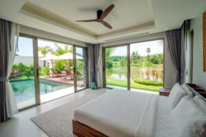 Спальня с видом на бассейн и озеро в вилле Botanica Lakeside II